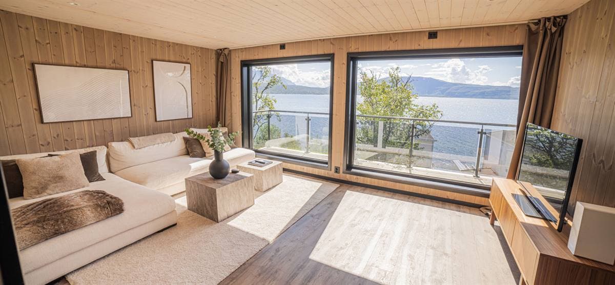 Stue med hvit sofa og panoramavinduer