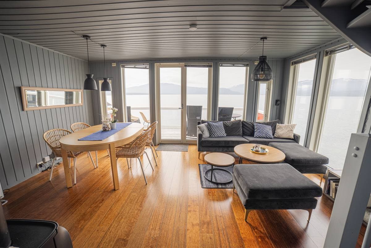 Stue med spisebord og fjordutsikt