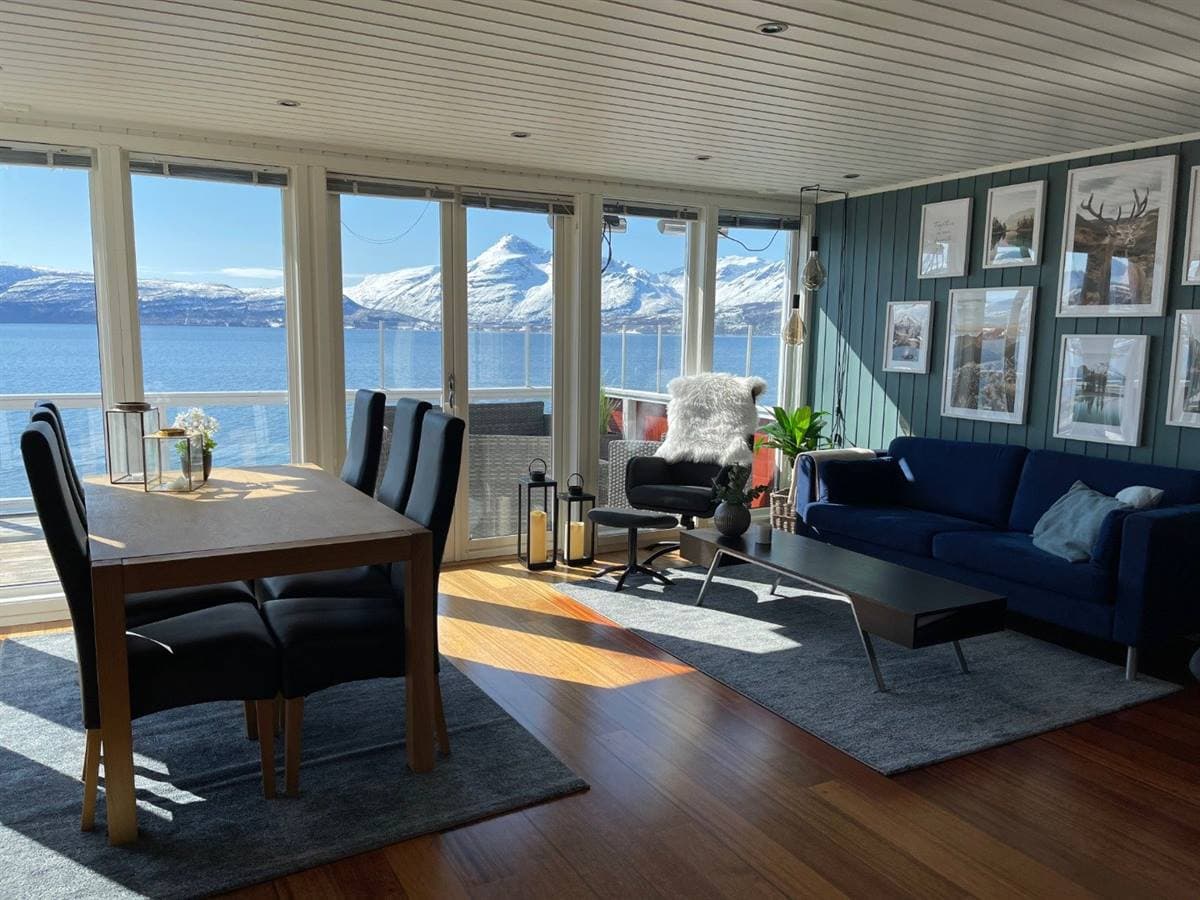Stue og spisestue med utsikt over fjorden og fjellene