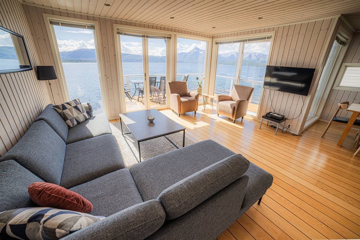 Stue med grå sofa og fjordutsikt