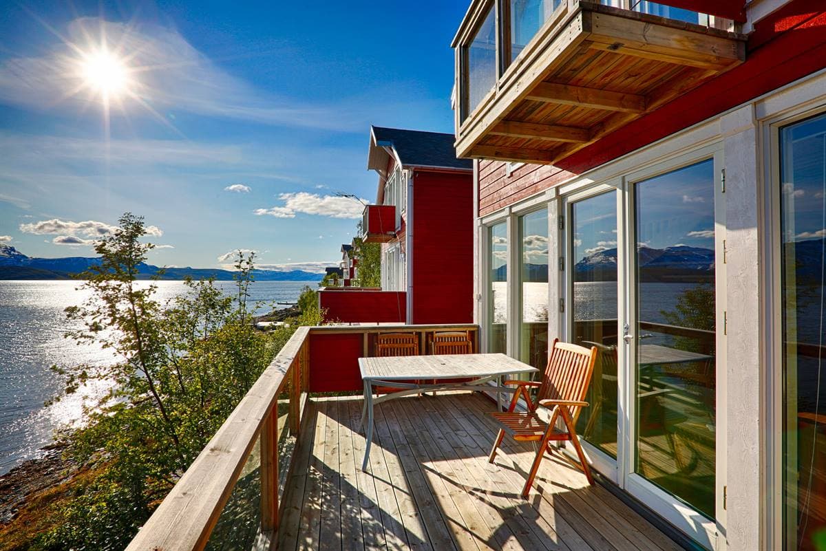 Balkong med bord og stoler over fjorden