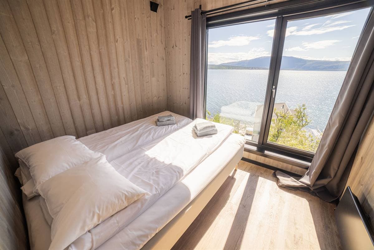 Soverom med dobbeltseng og vindu mot fjorden