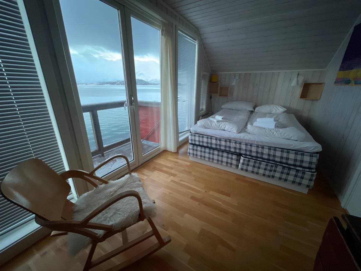 Soverom med dobbeltseng, vindu mot fjorden og gyngestol
