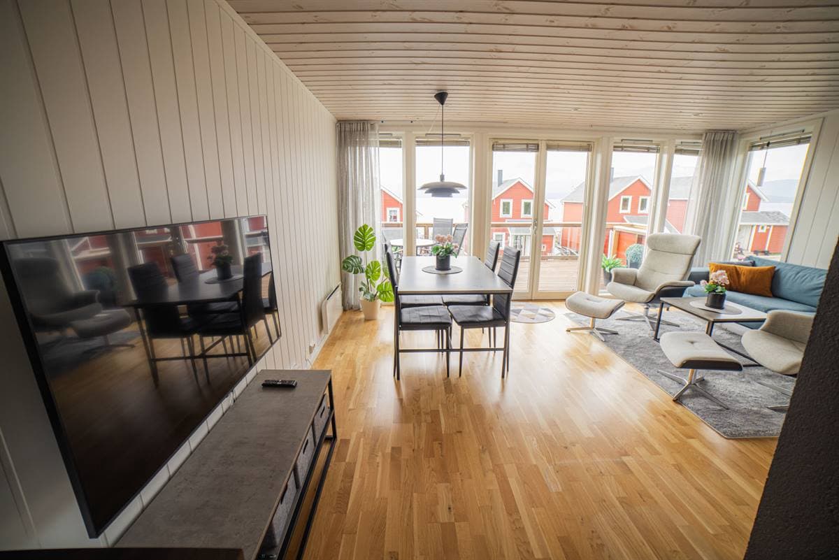 Åpen stue og spisestue med store vinduer